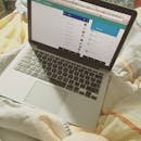 pexels-photo-376704-376704 A laptop showing a social media interface on a bed, top view, showcasing technology use in a cozy setting.