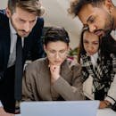 pexels-photo-7691691-7691691 A diverse group of professionals intensely collaborating over a laptop indoors.